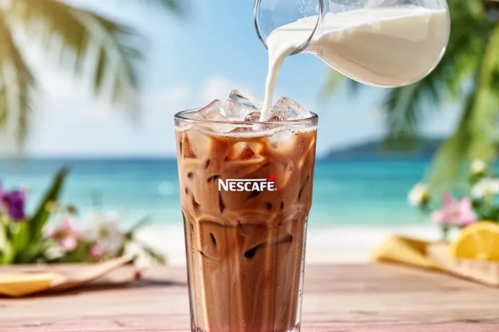 iced coffee with Nescafe tall glass with ice milk being poured summer vibes